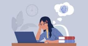 Woman working on a laptop looking stressed out