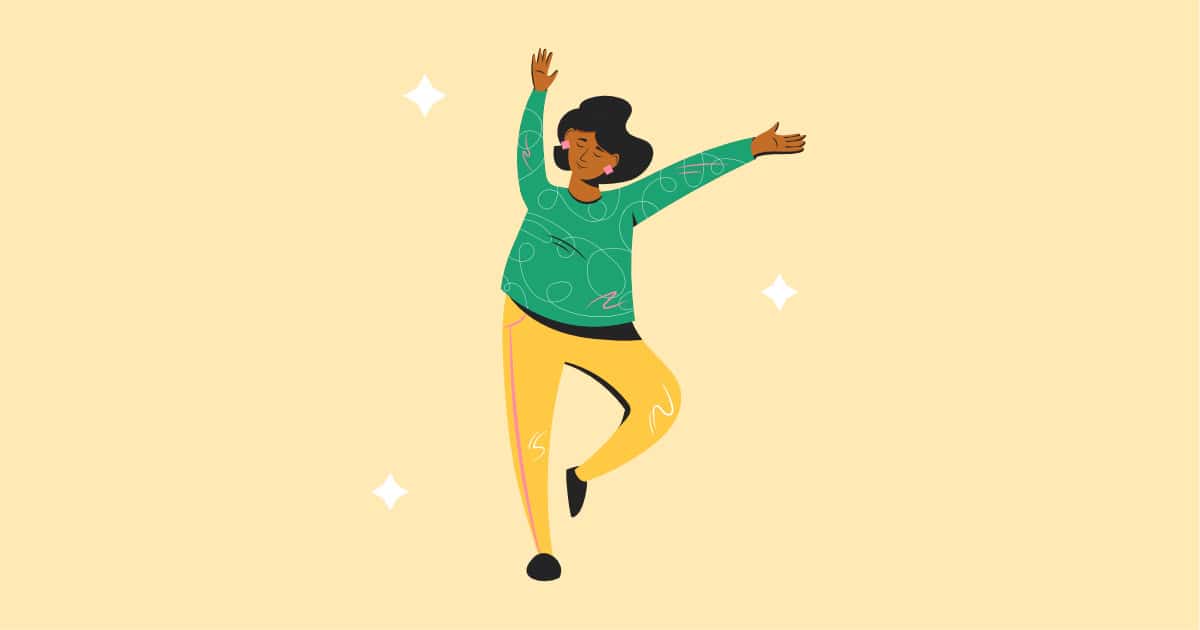 joyful woman dancing in front of yellow background